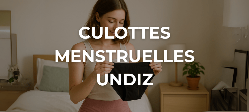 Jeune femme souriante examinant une culotte menstruelle noire Undiz dans une chambre lumineuse et naturelle