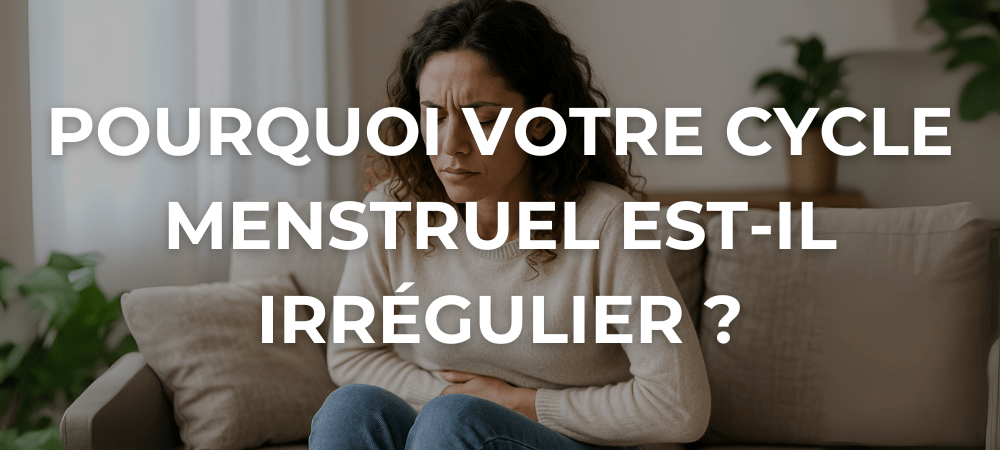 Femme assise sur un canapé, tenant son bas-ventre avec une expression de gêne, illustrant une douleur menstruelle dans un intérieur chaleureux.